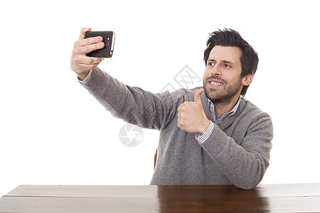 采取自拍相机微笑手机电话技术乐趣男性桌子快乐成人图片