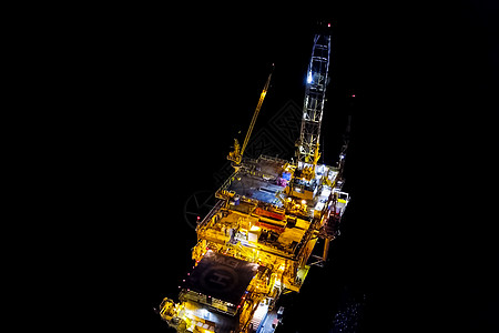 夜间石油平台 照着它自己的照明灯光血管拖船勘探海景钻孔力量起重机商业海岸技术图片