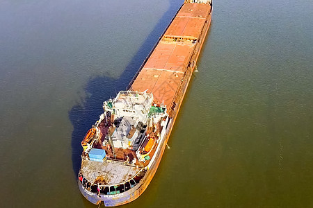 一艘货船沿河漂浮 货物船载体旅行海岸拖船港口后勤蓝色货运船运城市图片