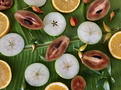 香蕉叶上新鲜热带异国情调水果的背景图片