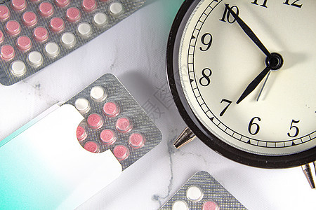 有时钟和大理石背景的避孕药图片