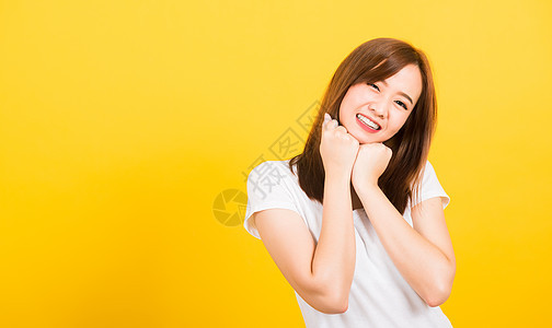 女青少年站着穿T恤衫 快乐的表情拳头工作室黄色女孩牙齿冒充下巴头巾女性情绪女士图片