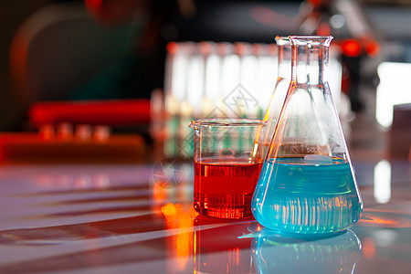 发光的实验室烧瓶 里面装满了五颜六色的化学溶液 桌子上有阴影 实验室 科学 化学概念蓝色瓶子测试液体量筒化学品橙子器皿烧杯制药图片