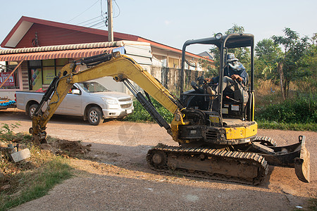 建造时的施工工程 在地上移动作业的黄色挖土机砂砾搬运工工作运输设施建筑反铲车辆采矿机械图片