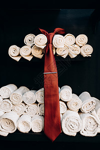在理发店的折叠白毛巾背景上的红色红领带图片