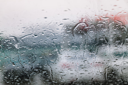 在寒冷潮湿的日子里 车流停滞不前 透过挡风玻璃拍摄 聚焦雨滴 尾灯失焦 查看从汽车玻璃窗 概念性的恶劣天气背景淋浴涟漪情绪压力飞图片