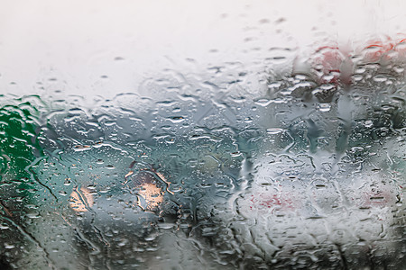 在寒冷潮湿的日子里 车流停滞不前 透过挡风玻璃拍摄 聚焦雨滴 尾灯失焦 查看从汽车玻璃窗 概念性的恶劣天气背景帮助静脉辉光夜生活图片