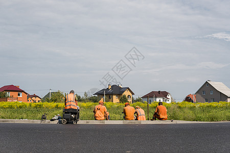 4名工人停靠在公路建筑工地 后面有一栋房屋收音机建设者对讲机衣领蓝色讨论职场操作领班头盔图片