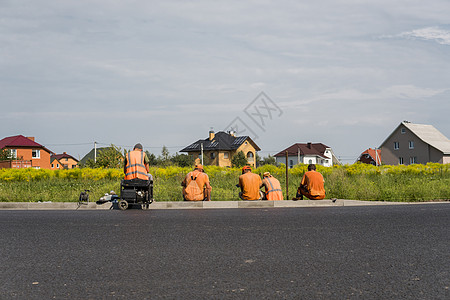 就业难素材4名工人停靠在公路建筑工地 后面有一栋房屋男性就业经理工作蓝色背心导师男人对讲机讨论背景