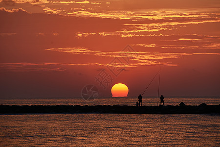 太阳在防晒水的渔民中出现支撑海岸旅行海洋日出岩石日落海浪灯塔天空图片