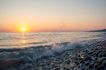 海上日落地平线卵石石头岩石波浪海景晴天蓝色太阳旅行图片