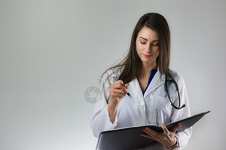 在纸质平板上写处方的护士或女医生 手拿笔 进行病人护理;图片