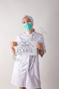 戴面罩的女医生手里握着一块石板     待在家里暴发生物面具危险感染预防疾病警告卫生危害图片
