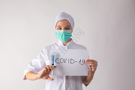 戴面罩的女医生手里拿着一块药片 并带有冠状病毒感染白色医疗医院药品呼吸警告面具临床诊断图片