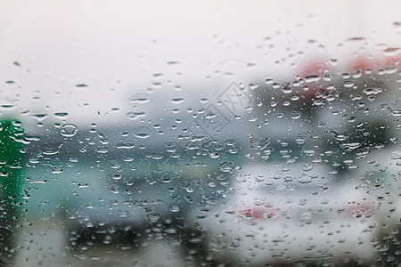 在寒冷潮湿的日子里 车流停滞不前 透过挡风玻璃拍摄 聚焦雨滴 尾灯失焦 查看从汽车玻璃窗 概念性的恶劣天气背景风暴涟漪大灯飞溅下图片