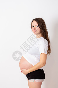年轻美丽的孕妇在白色背景上经历强烈的情绪 她很年轻 非常美丽孩子怀孕疾病分娩痛苦肚子产妇妈妈腹部生活图片