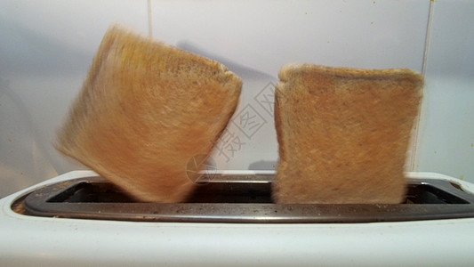 吐吐司飞出房子飞行烤面包机白色食物行动近景棕色苍蝇面包图片