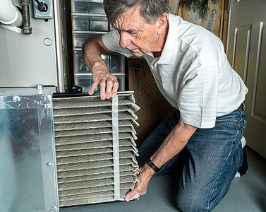 高级男子在更换脏空气过滤器成人安装工人地下室手指工作高效率暖通灰尘滤器图片