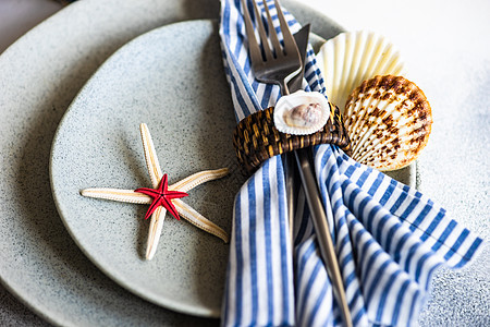 带有海星和贝壳的海洋表桌子假期热带餐巾环境制品石头餐具白色食物图片