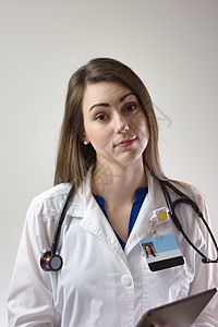 灰色背景的女医生 白大衣 听诊器 徽章可见快乐外科医院职业门厅走廊护士诊所从业者居民图片