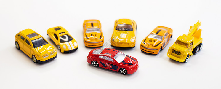橙色汽车包围着一辆红色汽车玩具蓝色游戏工厂铁皮反射团体运动腐蚀乐趣驾驶图片