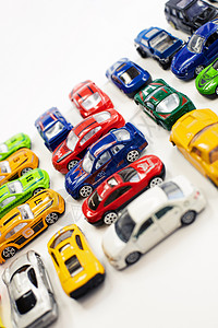 不同颜色的玩具车在白色背景上排列车辆游戏鸟瞰图铁皮反射驾驶收藏品蓝色工厂金属图片