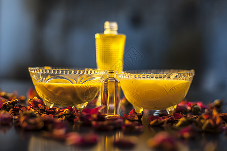 由椰子油与橄榄油 酥油和精油混合而成的天然护发剂 可使头发健康 整个成分在玻璃碗中与准备好的油一起呈现在表面上按摩发胶黄油疗法皮图片