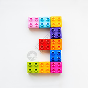 数字制作素材三号由彩色构造块制成 玩具积木按顺序放置 制作数字 3 教育过程-使用五颜六色的玩具细节与孩子一起学习数字背景