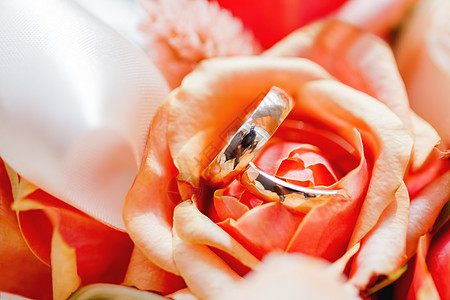 金婚戒指在花束中的橙色玫瑰花里 象征着爱和婚姻的象征图片