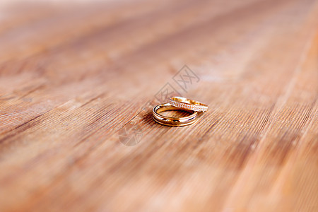 一对金色结婚戒指 在破旧的木制背景上镶有钻石 爱情婚姻的象征和第五个木制结婚纪念日奢华订婚珠宝假期庆典浪漫装饰品纪念日宏观宝石图片