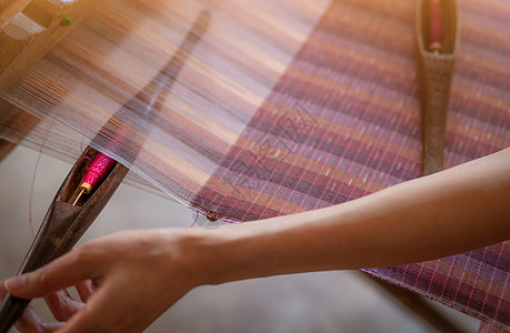 女性在编织手工织物的织造机上工作手工业工具机器丝绸艺术生产女士文化旅行工艺图片