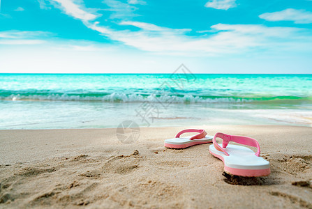 沙滩上的粉色和白色的凉鞋 是平时风格的翻滚式图片
