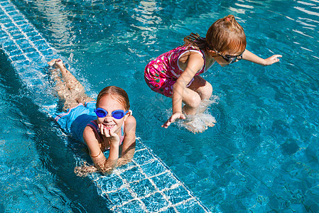 两个快乐的小女孩 在游泳池里冲浪青年喜悦水池游泳者乐趣姐姐游泳衣蓝色太阳学校图片