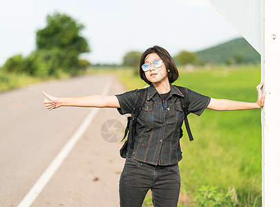 女人与背包搭便车在路上站在一起青少年路线游客自由女孩天空假期国家场地旅行图片