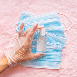 保护手套上顶部有防腐面具和透明瓶中洗涤剂 女医生 Corona病毒COVID-19概念 粉红色折叠背景图片