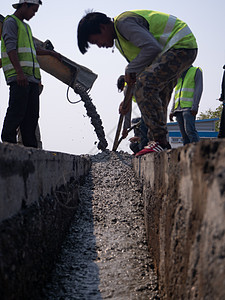 在升级至住宅街道期间 水泥堆积的建筑液体男人管子机器工人住宅维修建造民众头盔图片