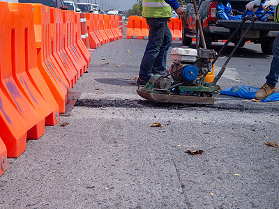 工人在公路上使用振动板板压实机工程铺路道路机器工具振动维修压实机沥青柏油图片