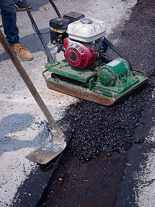 工人在公路上使用振动板板压实机机械维修压力装修沥青街道蒸汽振动器盘子路面图片