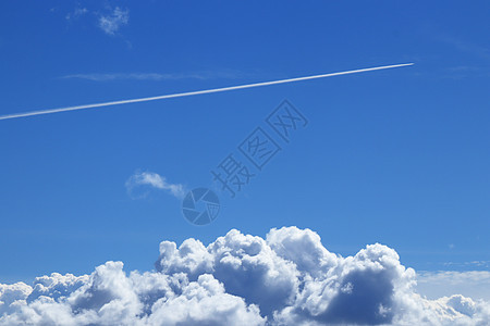 飞机的踪迹 在一片晴朗的蓝色天空中 大云层上图片