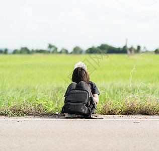 女人坐着背包搭便车在路上假期自由游客旅行冒险国家天空女性青少年路线图片