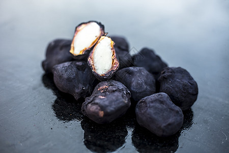 黑色木质表面的新鲜有机原生水栗子 其中一块被切掉生产种子植物饮食蔬菜皮肤农业食物健康水果图片