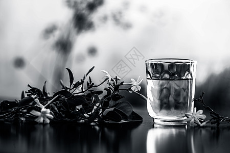 印度茉莉花或Juhi或在木质表面用透明玻璃和鲜花提取的甘油香气药品植物学叶子植物瓶子皮肤化妆品香味实验室图片