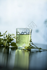 印度茉莉花或Juhi或在木质表面用透明玻璃和鲜花提取的甘油三叶草药品草本植物茉莉叶子实验室温泉香味化妆品酊剂图片