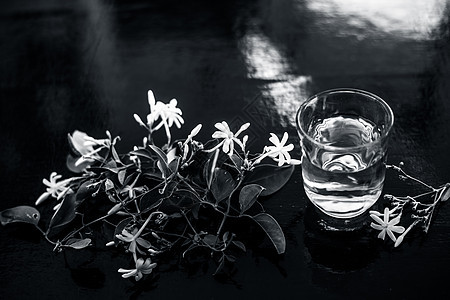 印度茉莉花或Juhi或在木质表面用透明玻璃和鲜花提取的甘油植物草本植物治疗叶子护理植物学香气酊剂温泉香味图片