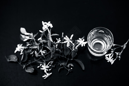 印度茉莉花或Juhi或在木质表面用透明玻璃和鲜花提取的甘油植物学治疗萃取温泉药品皮肤护理植物香气香味图片