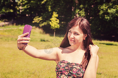 年轻女孩在公园做自拍手机幸福照片成人女士女性电话图片