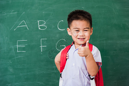 身着校服 有书包和Bob学生制服的幼童幼儿园男生手势黑板手指绿色快乐微笑孩子学习童年图片