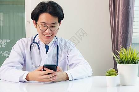 医生用智能手机工作时微笑的女医生男人职场互联网医院电脑阅读药品电话办公室桌子图片