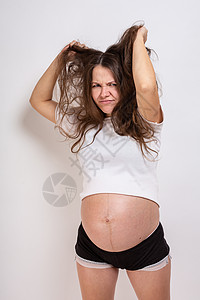 年轻美丽的孕妇在白色背景上经历强烈的情绪 她很年轻 非常美丽产妇母亲婴儿身体疼痛父母压力妈妈腹部症状图片