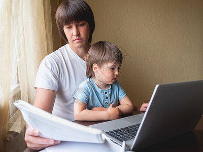 人类和他的小儿子在远程工作 笔记本电脑放在桌子上 掌上型电脑在线工具家庭男生卫生保健孩子技术儿子自由职业者图片